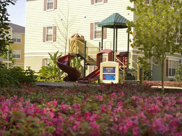a playground with a slide in front of a house