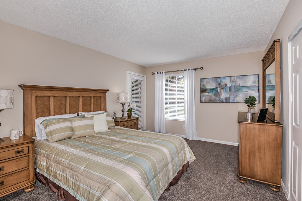 a bedroom with a bed and a dresser and a window