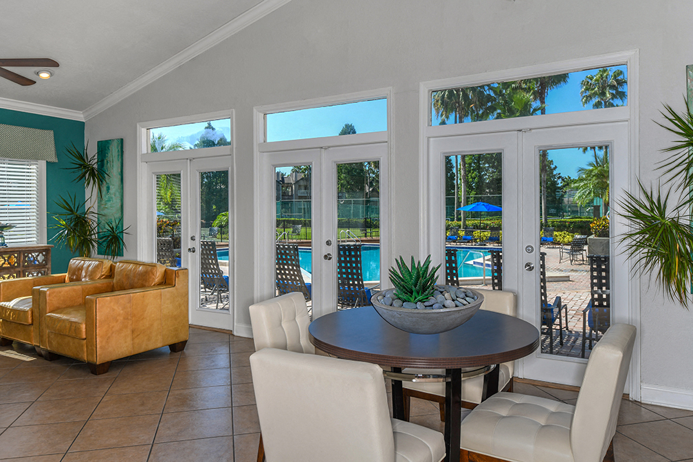 a living room with a table and chairs and a view of a swimming pool