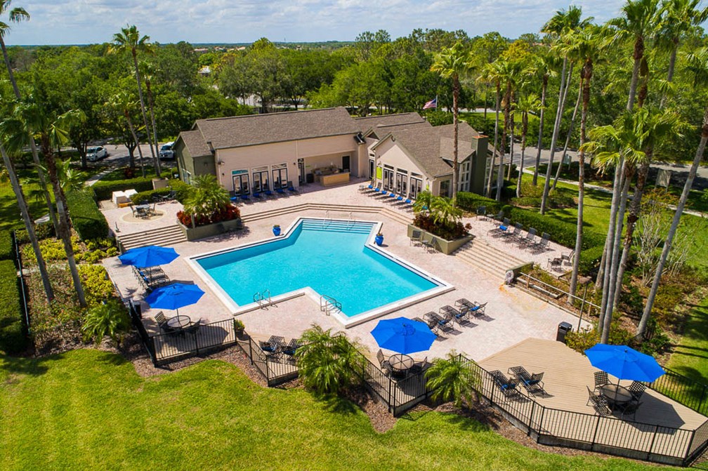 a swimming pool with umbrellas and chairs around a resort style pool
