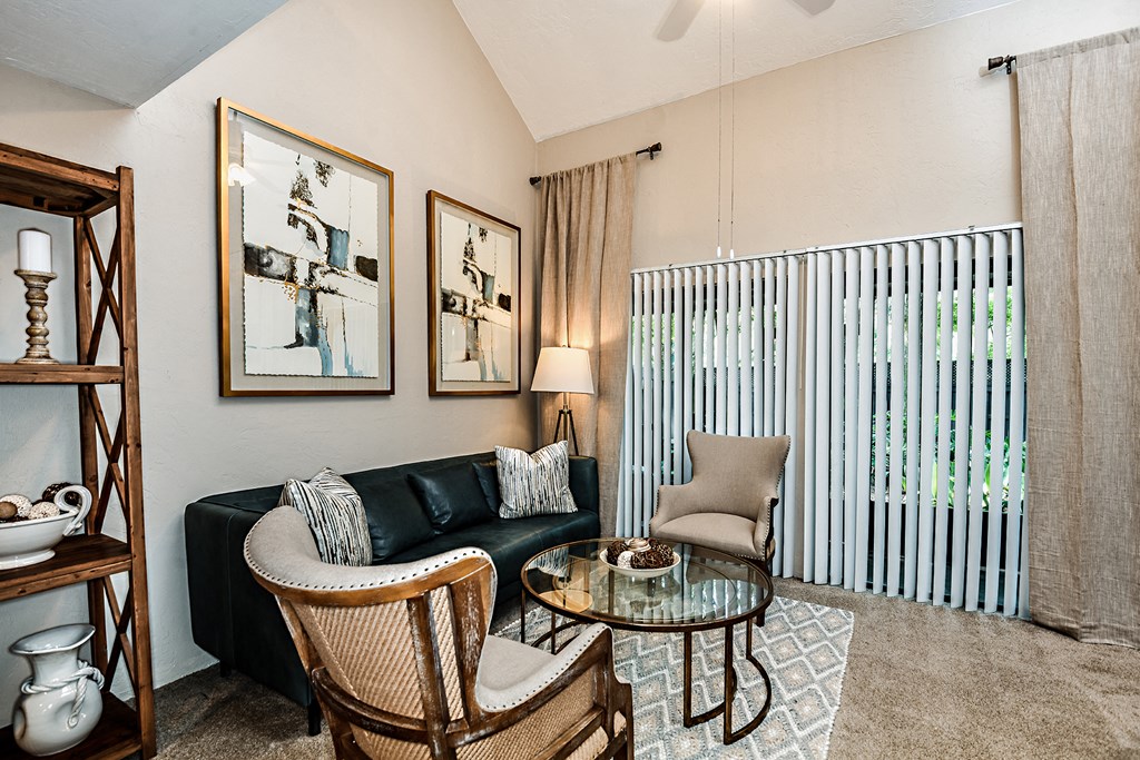 a living room with a couch and two chairs and a table