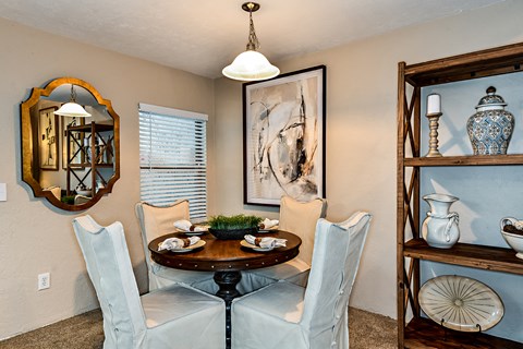 a dining room with a table and chairs and a mirror