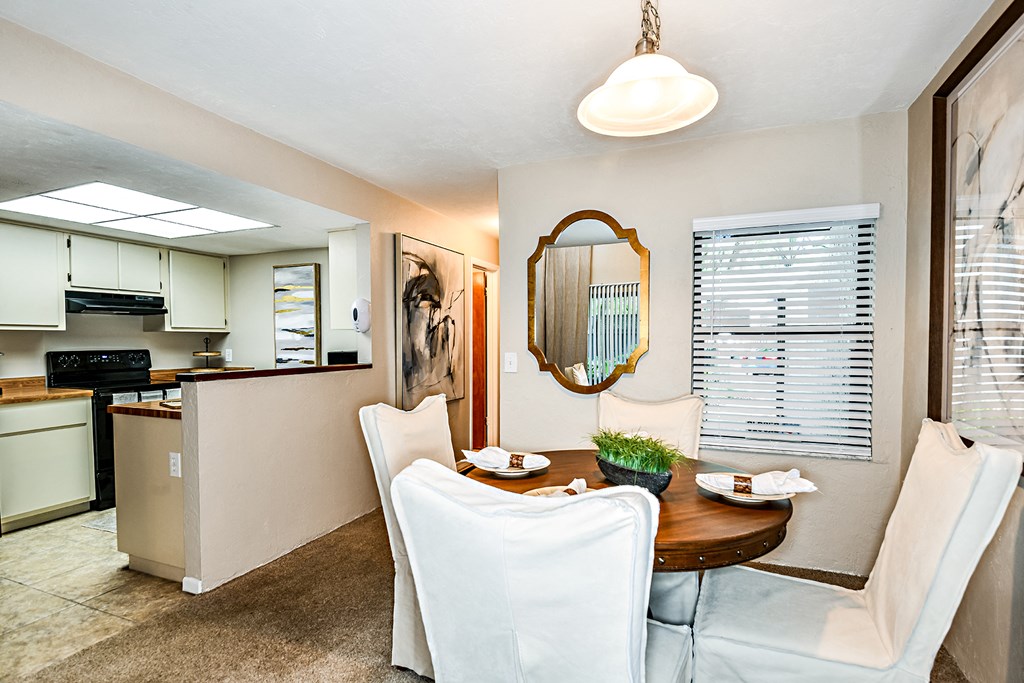 a dining room and kitchen with a table and chairs