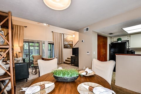 the living room has a dining table with plates and chairs