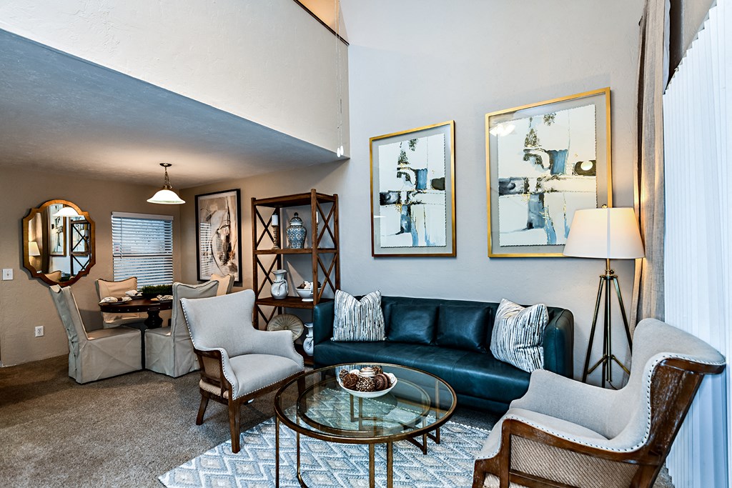 a living room with a blue couch and chairs and a glass table