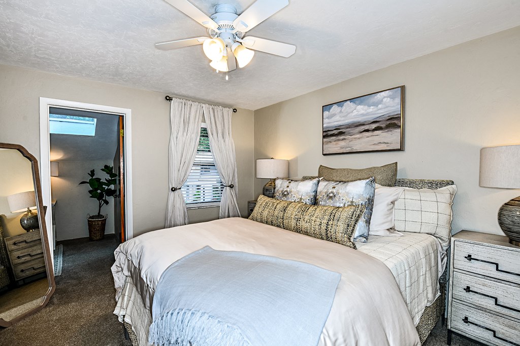 the master bedroom has a large bed and a ceiling fan