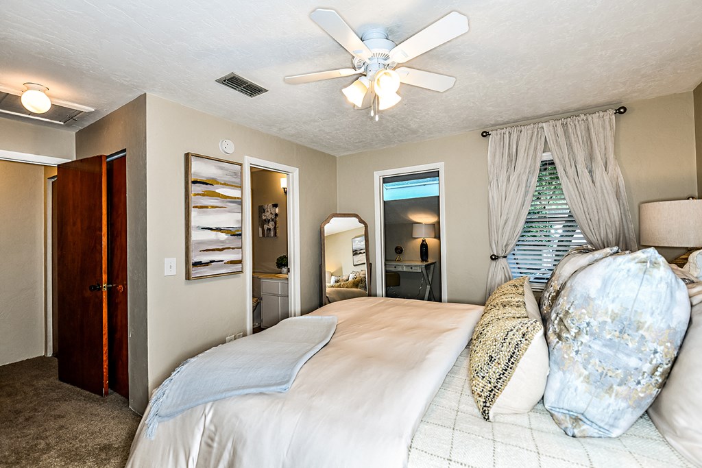 a bedroom with a large bed and a ceiling fan