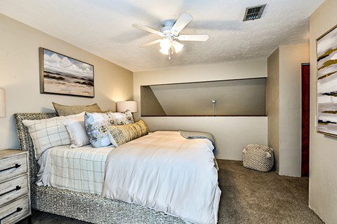 a bedroom with a bed and a ceiling fan