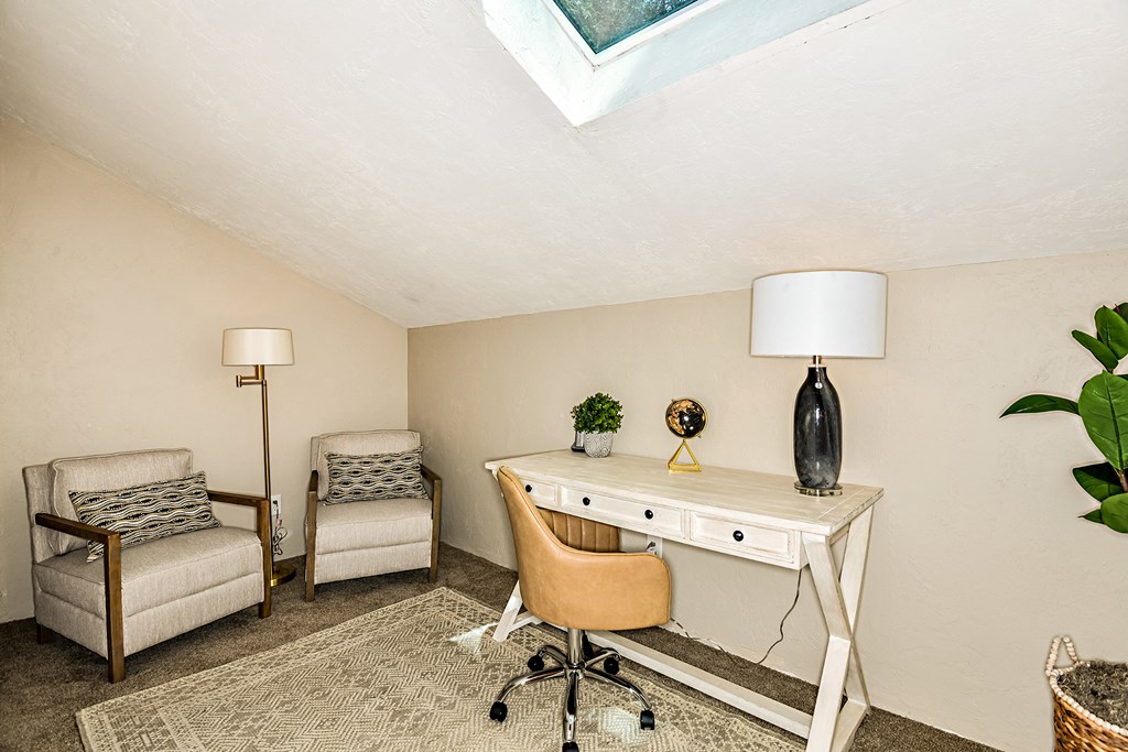 a home office with a desk and chair and a window