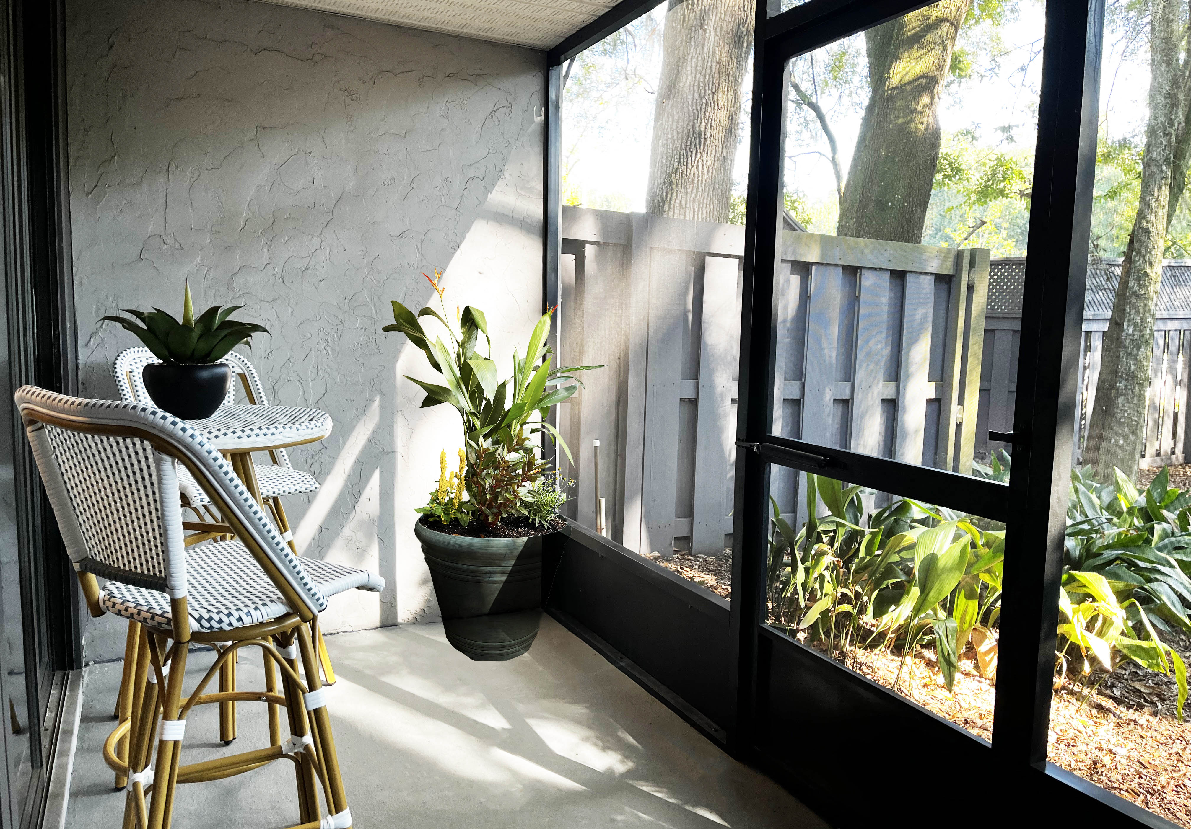 a patio with a table and chairs and a window