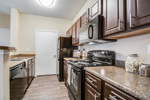 the kitchen of our studio apartment atrium with granite counter tops and black appliances
