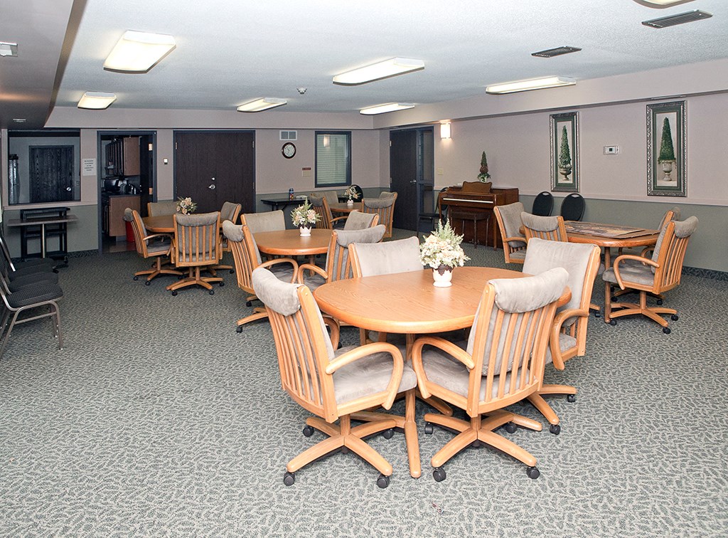 a multipurpose room with tables and chairs and a piano
