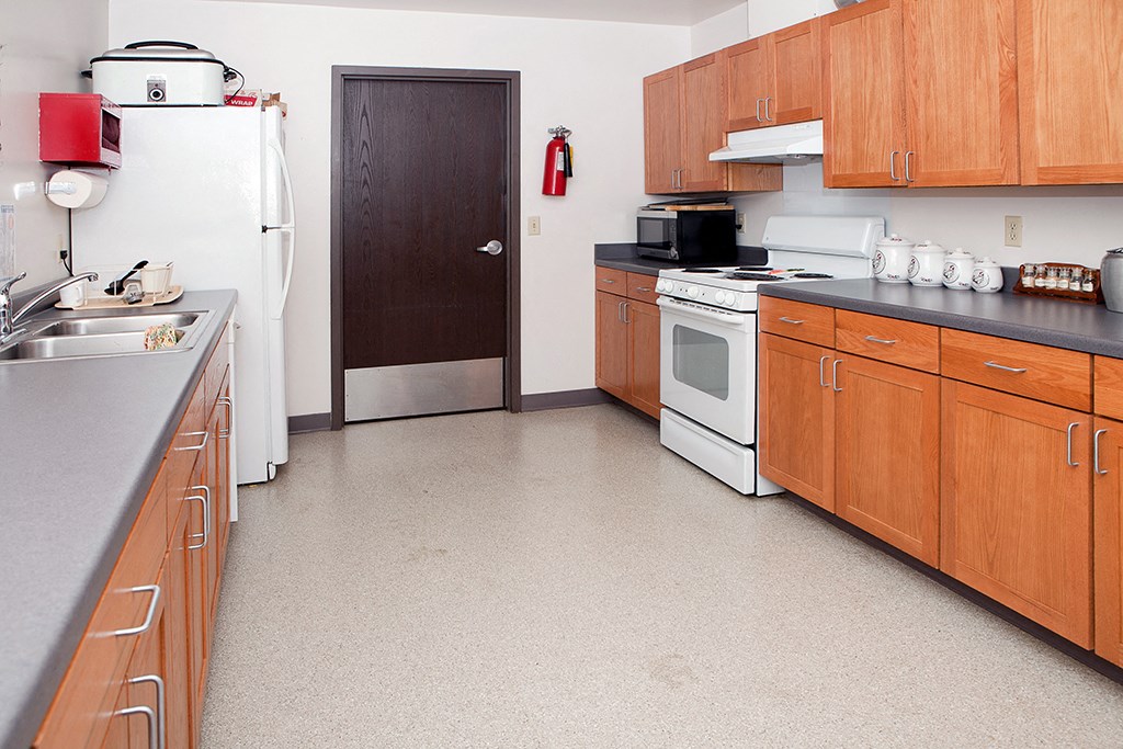 a kitchen with wood cabinets and white appliances and a refrigerator