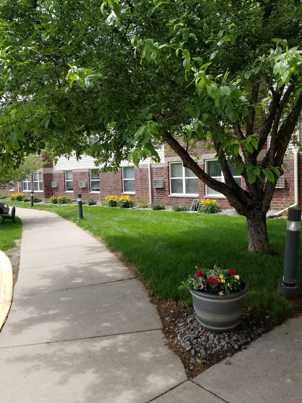 a sidewalk in front of a brick building
