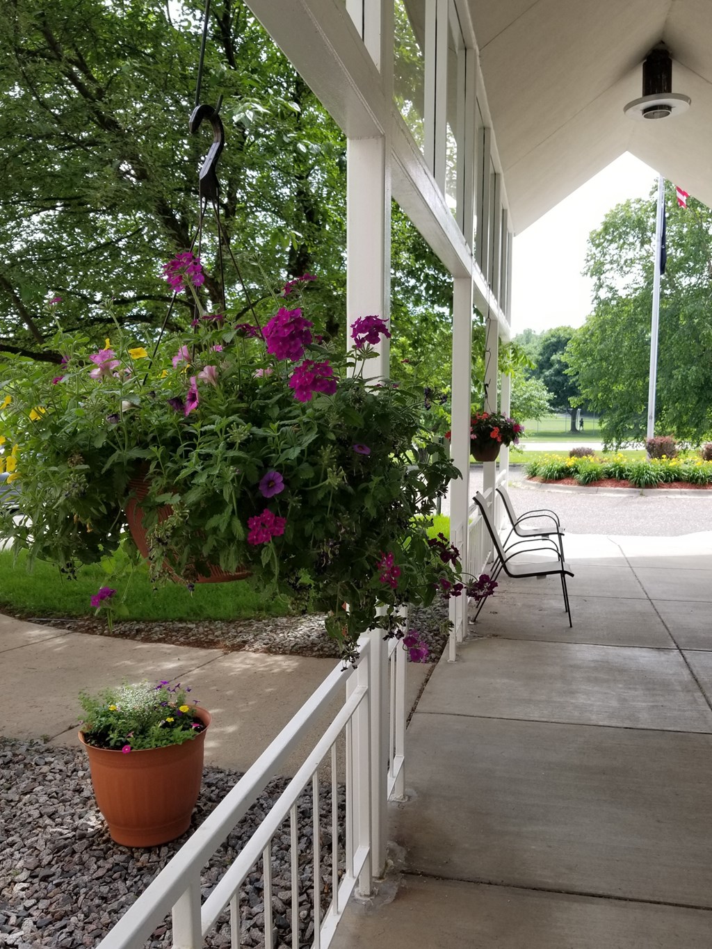 a porch with flowers and a chair on it