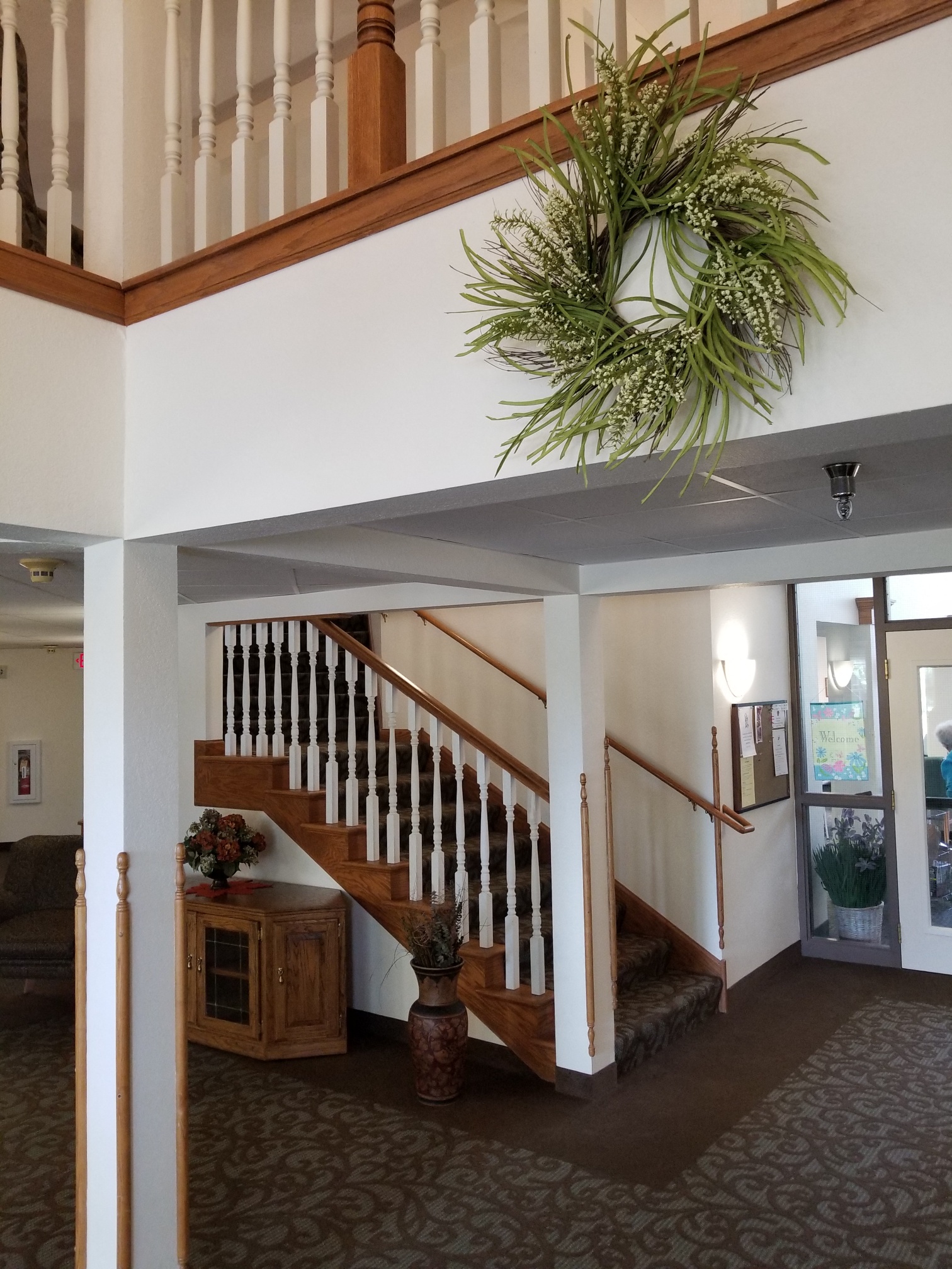 a view of the stairs in the lobby of a building with a potted plant