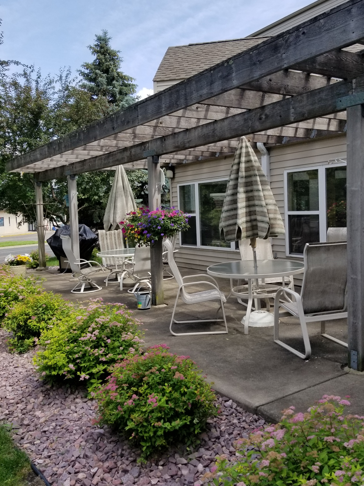 a patio with chairs and tables and a pergola