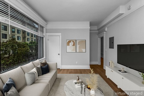 A living room with a couch, a coffee table, and a television.