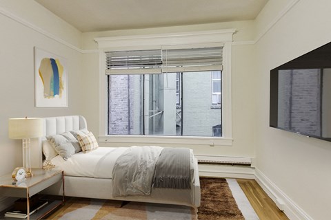 a bedroom with a large window and a bed with pillows