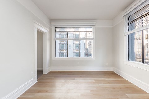 A room with a large window and wooden flooring.