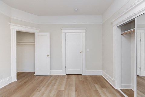 A room with white doors and a wooden floor.