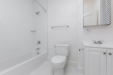 A white bathroom with a toilet, sink, and bathtub.