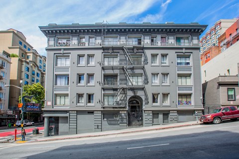 A large grey building with a fire escape on the front.