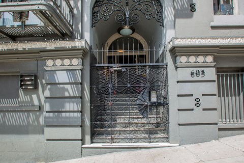 A wrought iron gate blocks the entrance to a building with the number 603 on the wall.