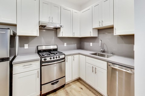 A kitchen with white cabinets and stainless steel appliances.