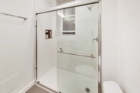 A white bathroom with a glass shower door.