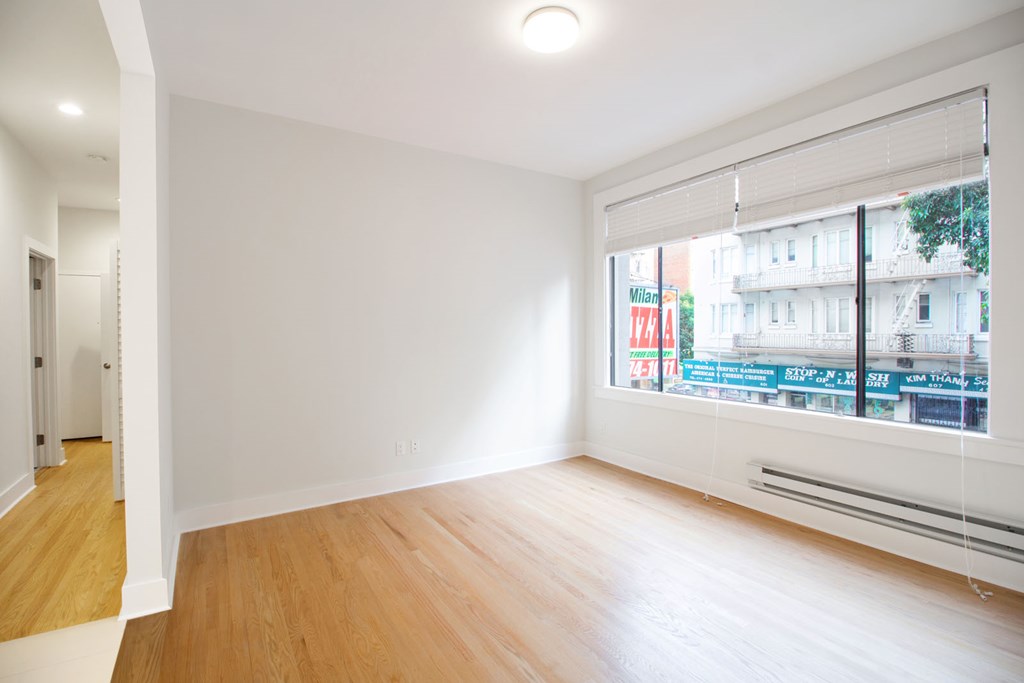 a living room with a large window and wooden floors