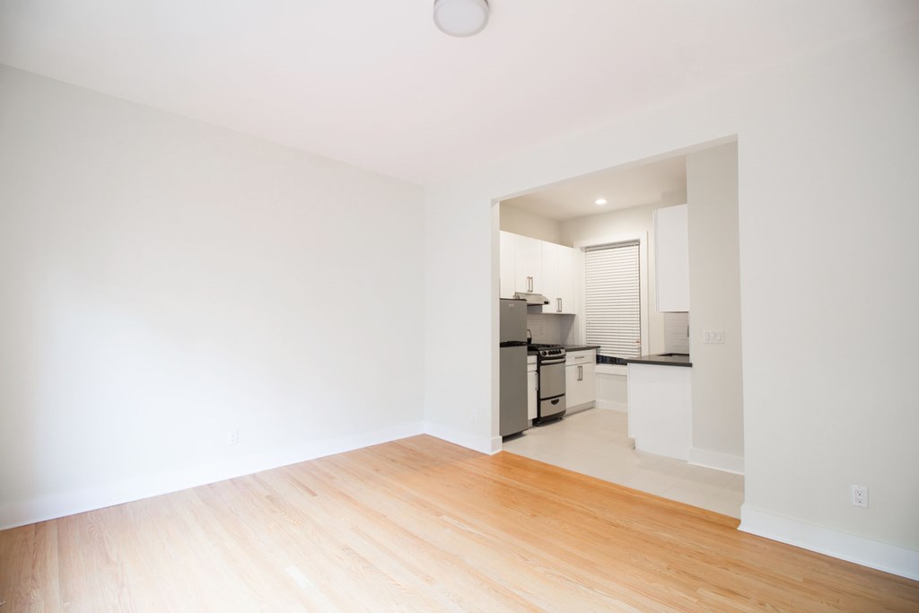 a living room and kitchen with a wooden floor