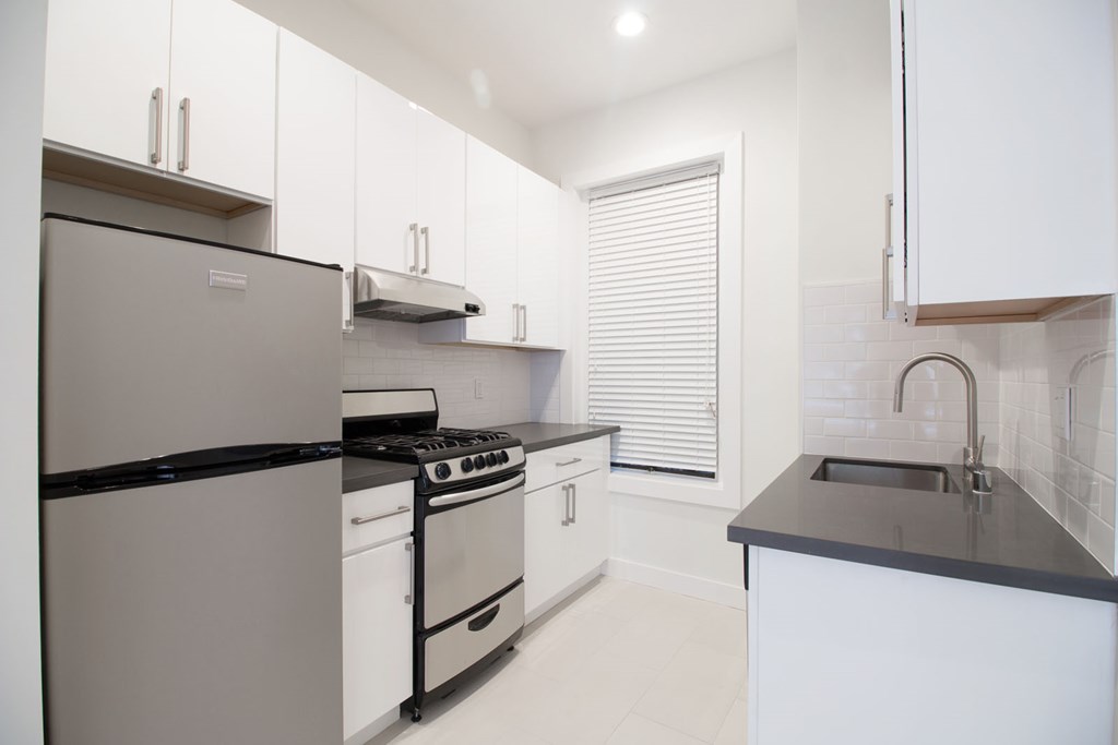 a kitchen with white cabinets and stainless steel appliances