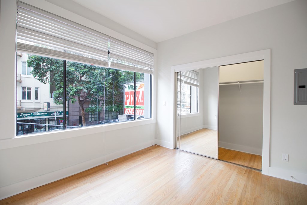 a living room with a large window and wooden floors