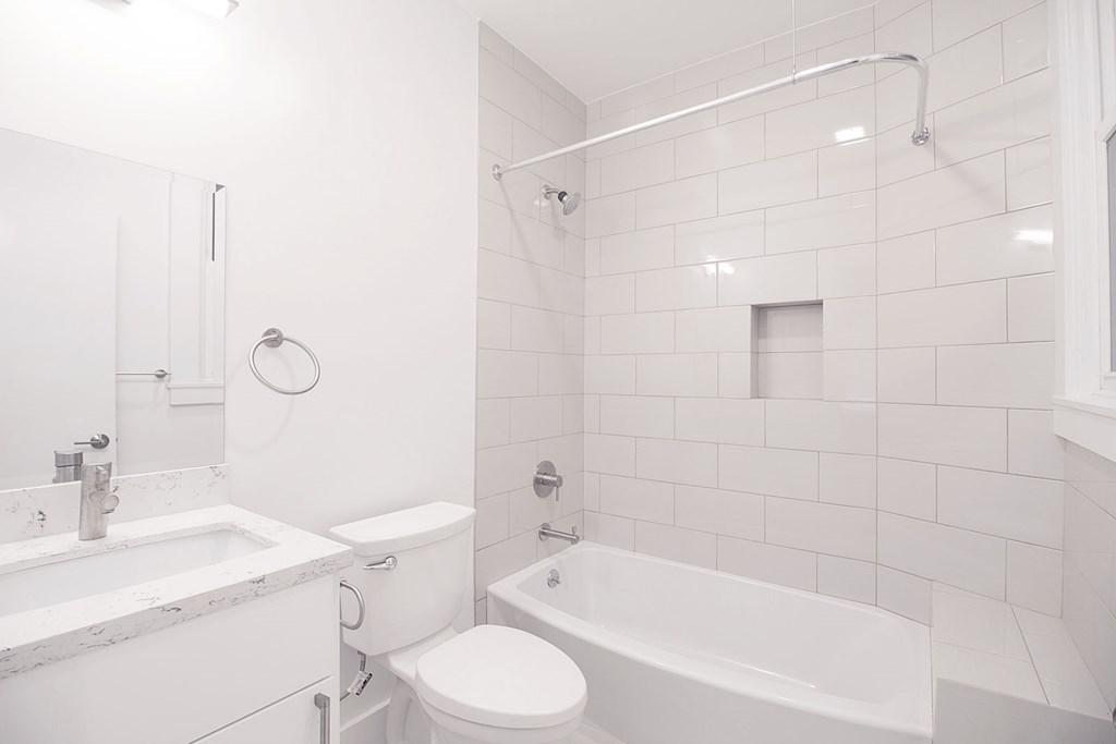 a white bathroom with a tub and a toilet and a sink