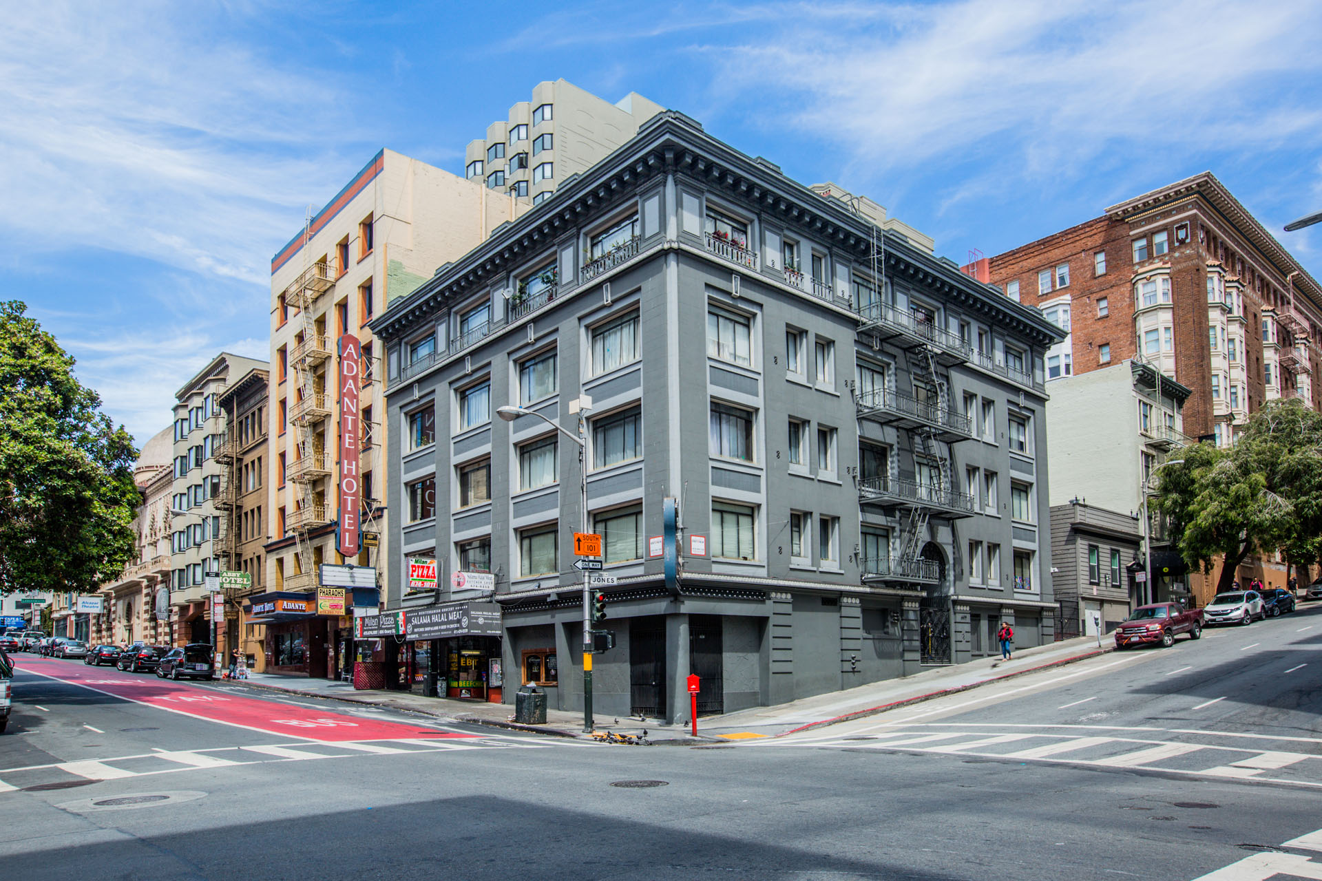 A street view of a city with a grey building in the center.