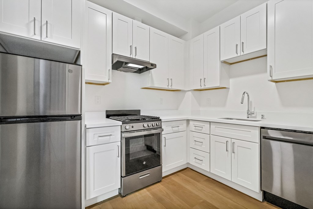 A modern kitchen with white cabinets and stainless steel appliances.