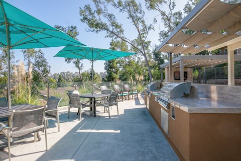 a patio with a bar and tables with umbrellas