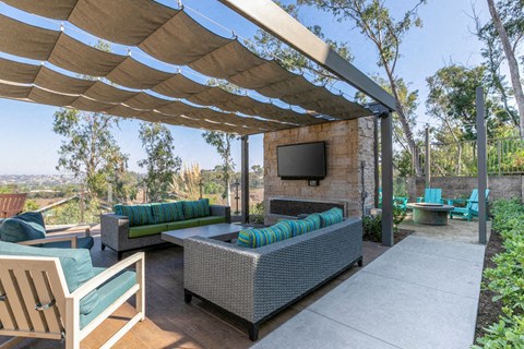 a covered patio with couches and a tv