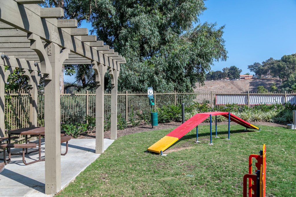 a playground with a slide and a picnic table in a backyard