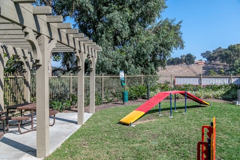 a playground with a slide and a picnic table in a backyard