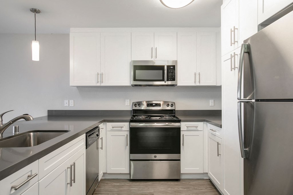 a kitchen with stainless steel appliances and white cabinets