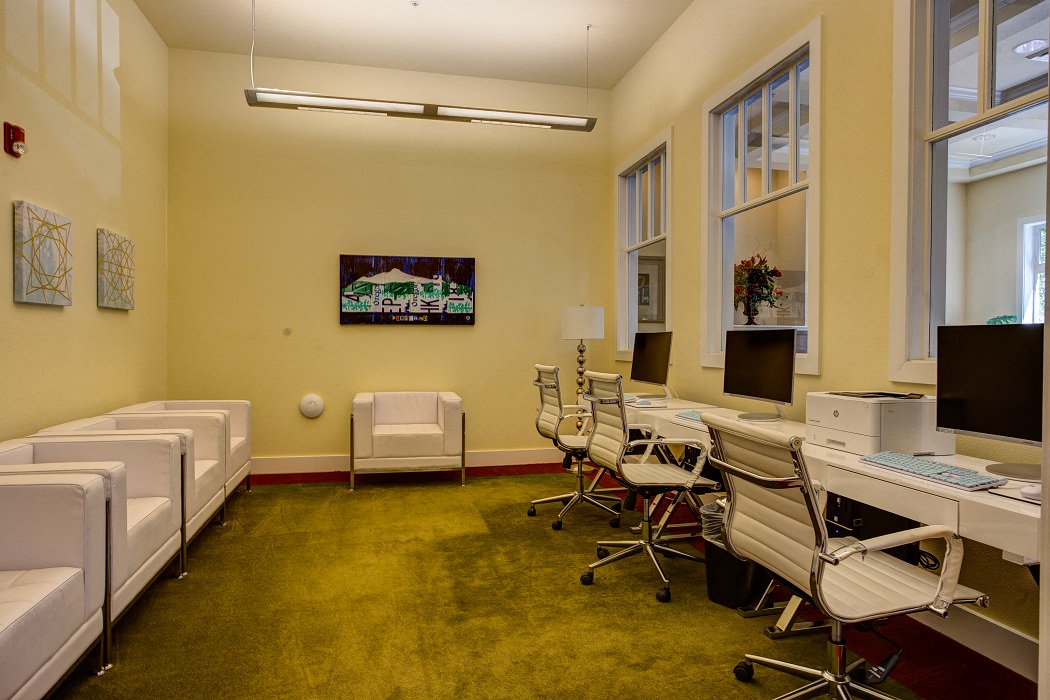 a conference room with desks and chairs and a tv