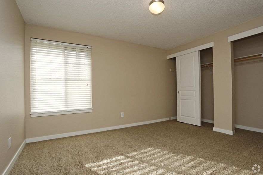 an empty living room with a closet and a window