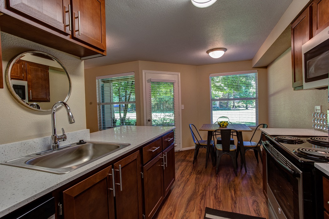 a kitchen with a sink and a table with chairs
