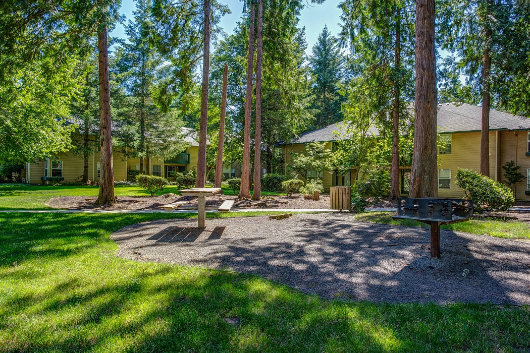 a picnic area with a picnic table in front of a yellow house