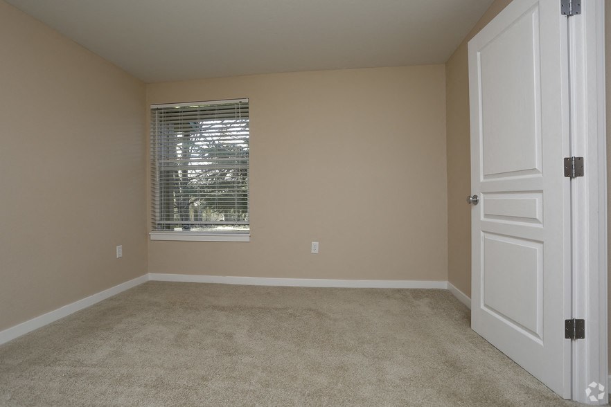 an empty room with a window and a white door