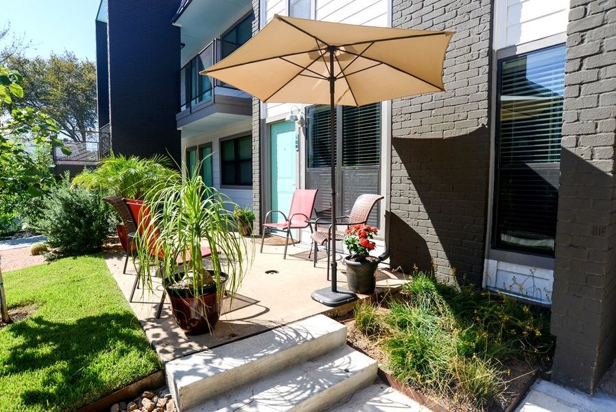 a patio with an umbrella and chairs on it