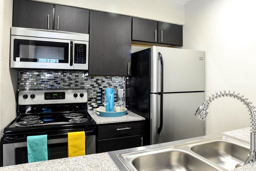 a kitchen with a stove refrigerator and sink
