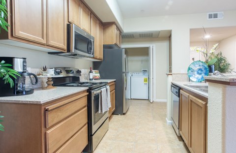 a kitchen with wood cabinets and stainless steel appliances and a refrigerator